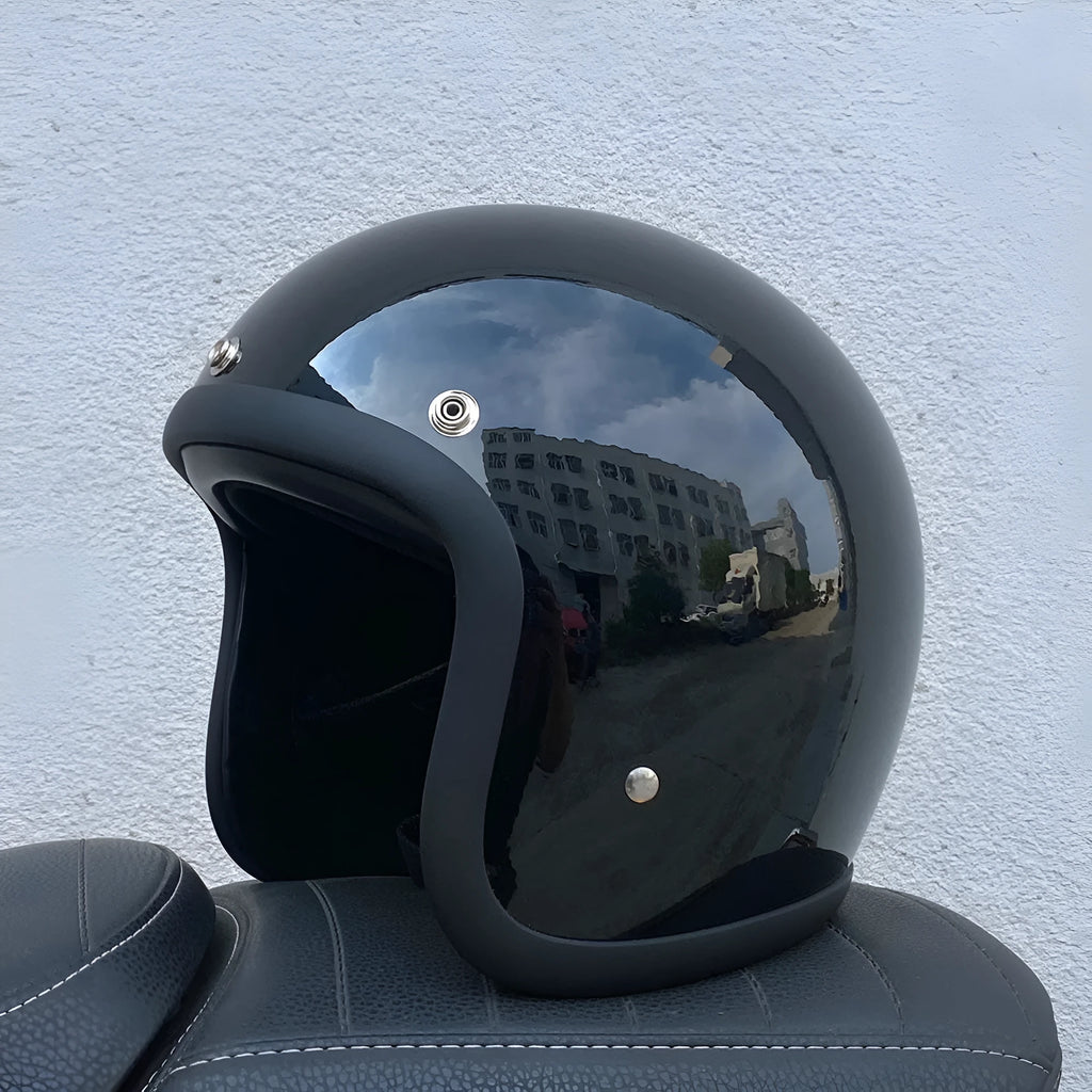Retro style fibreglass half motorcycle helmet shown in a choice of colours like cement grey and matte black.