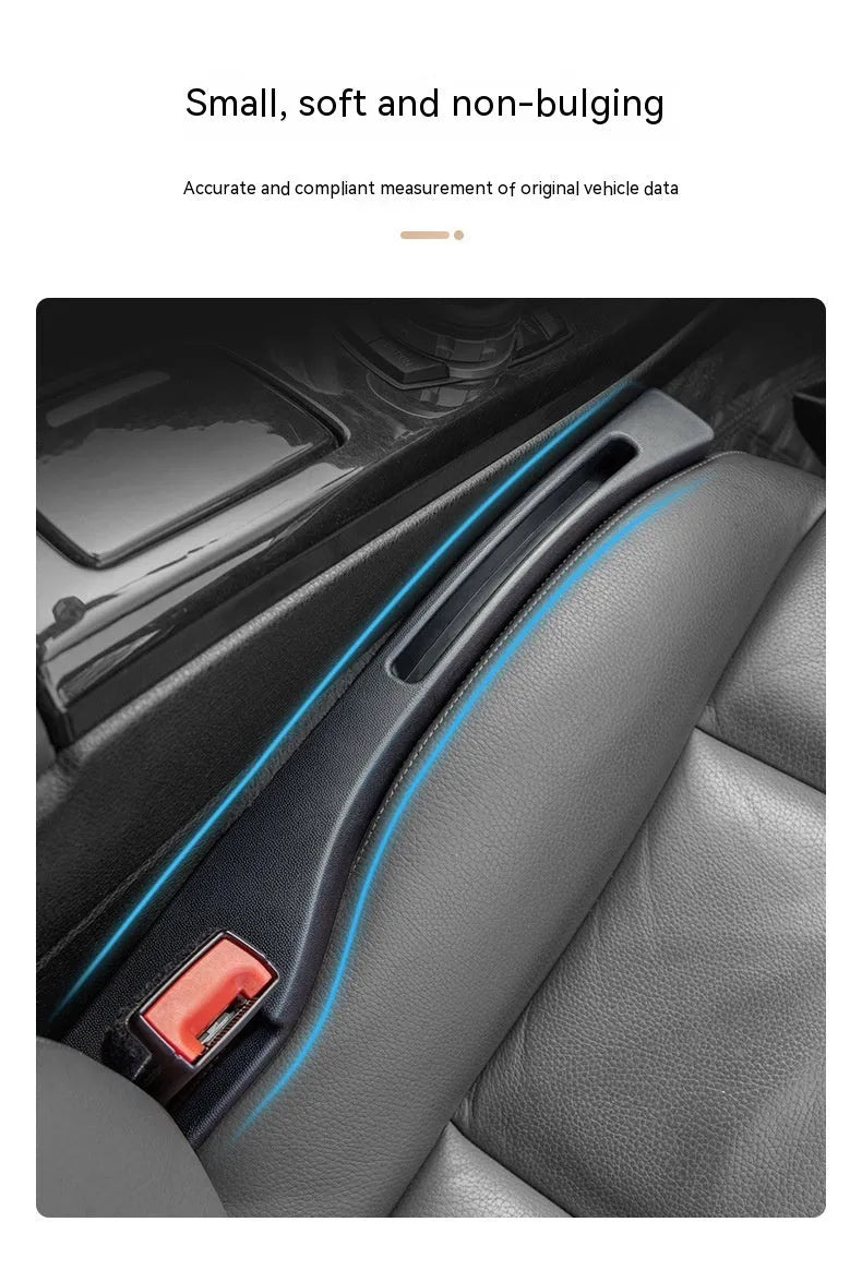 Black plastic car seat gap storage box with handle inserted between car seats.