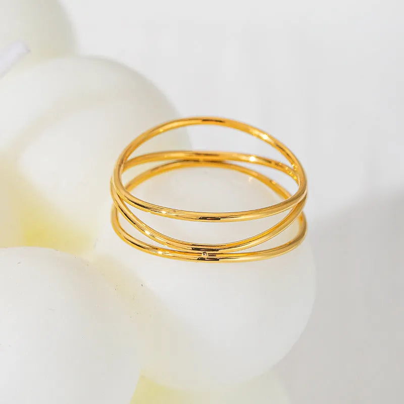 Geometric gold-coloured titanium steel ring with three-layer coil design shown at various angles