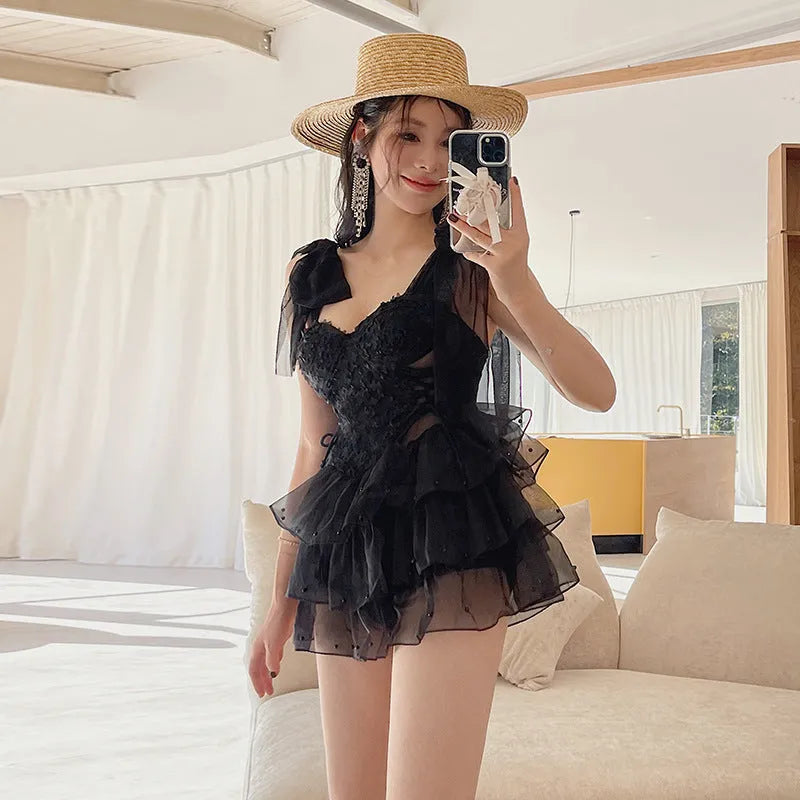 Black conservative one-piece swimsuit with gathered chest detail for belly coverage