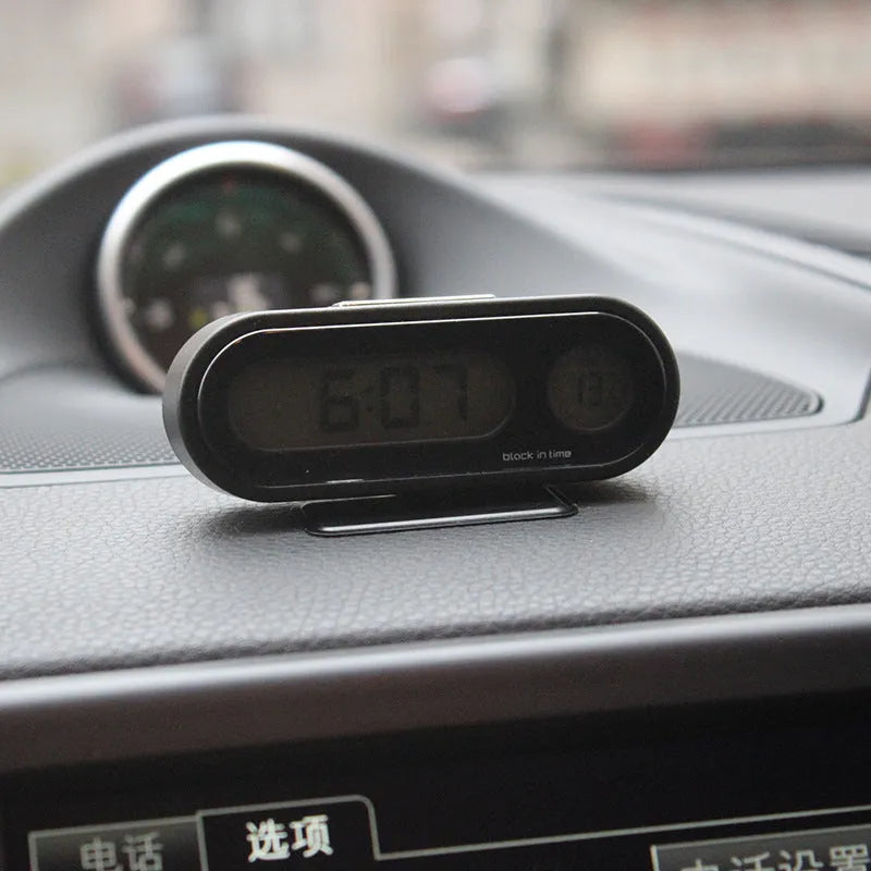 Black car dashboard clock thermometer with digital LED display showing time and temperature