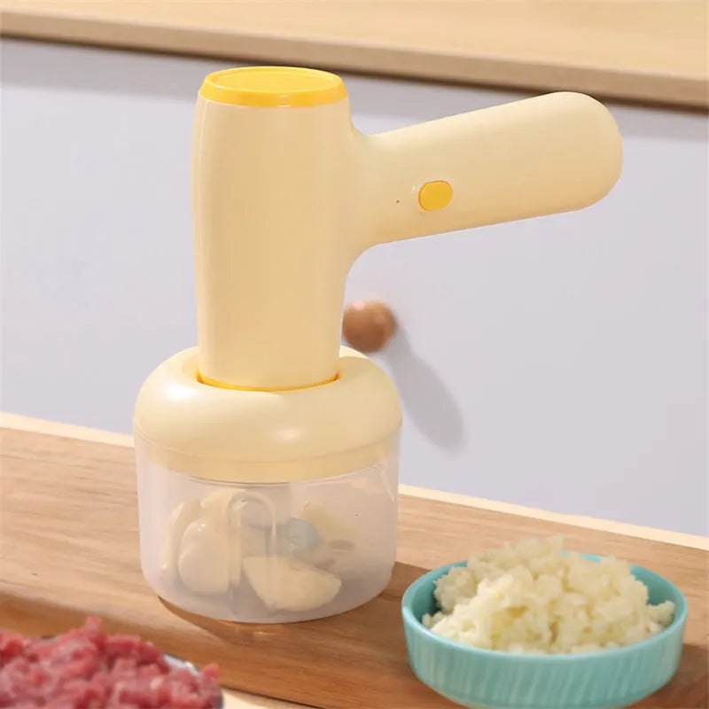Beige yellow USB rechargeable electric garlic chopper with 250ml cup and 304 blade on a kitchen counter