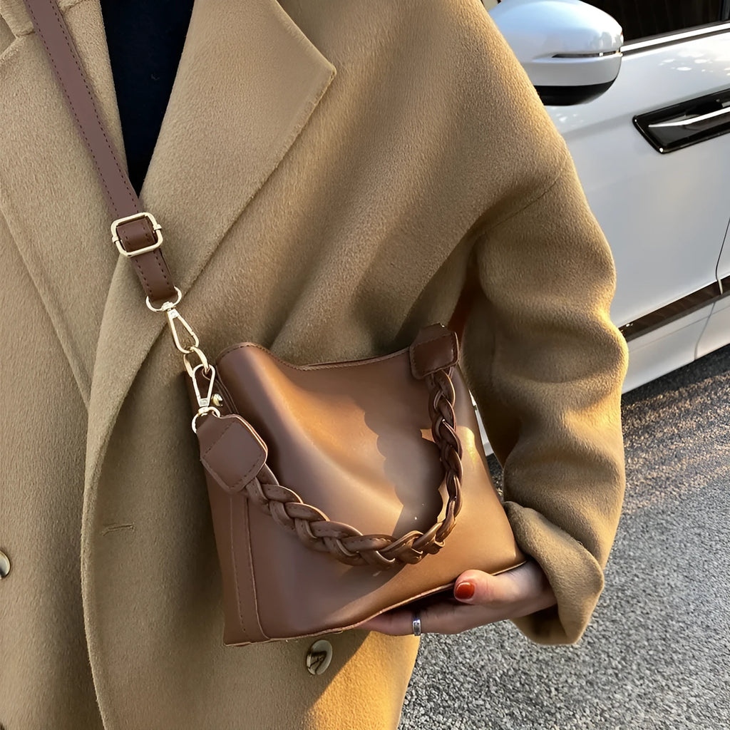 Retro style brown PU leather underarm bucket bag with woven design detail.