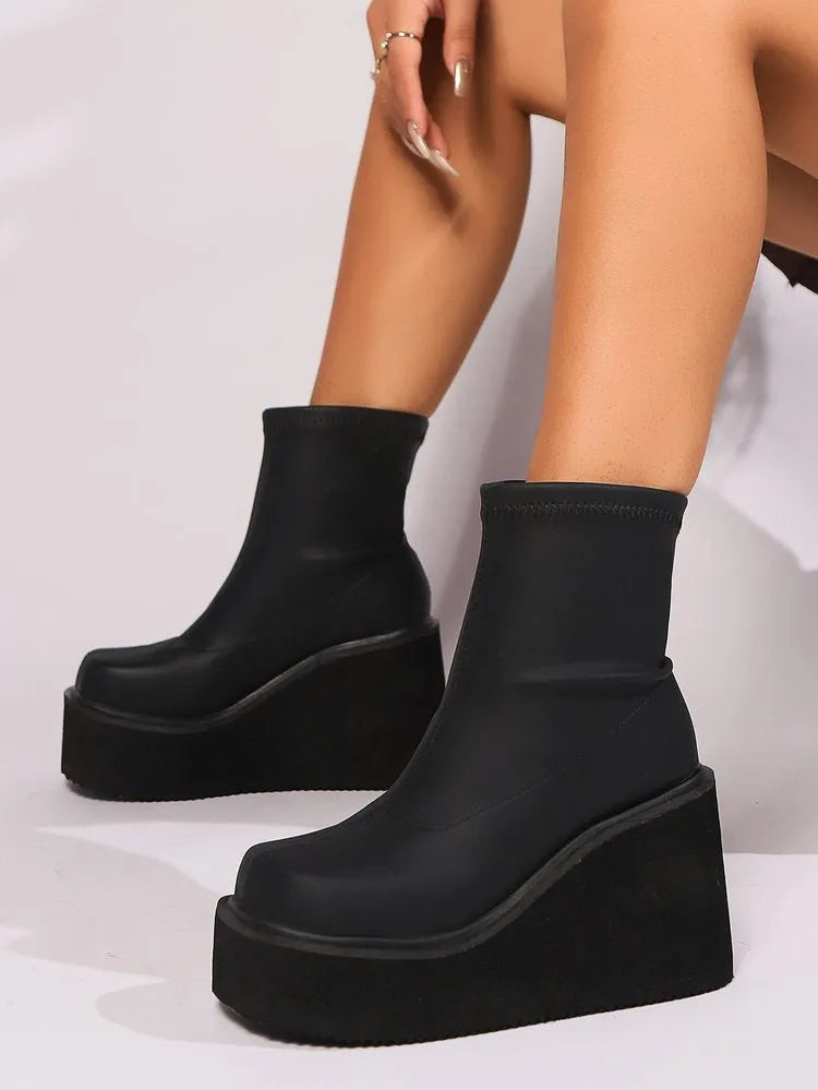Plus size black wedge heel boots with a waterproof platform and round toe on a white background.