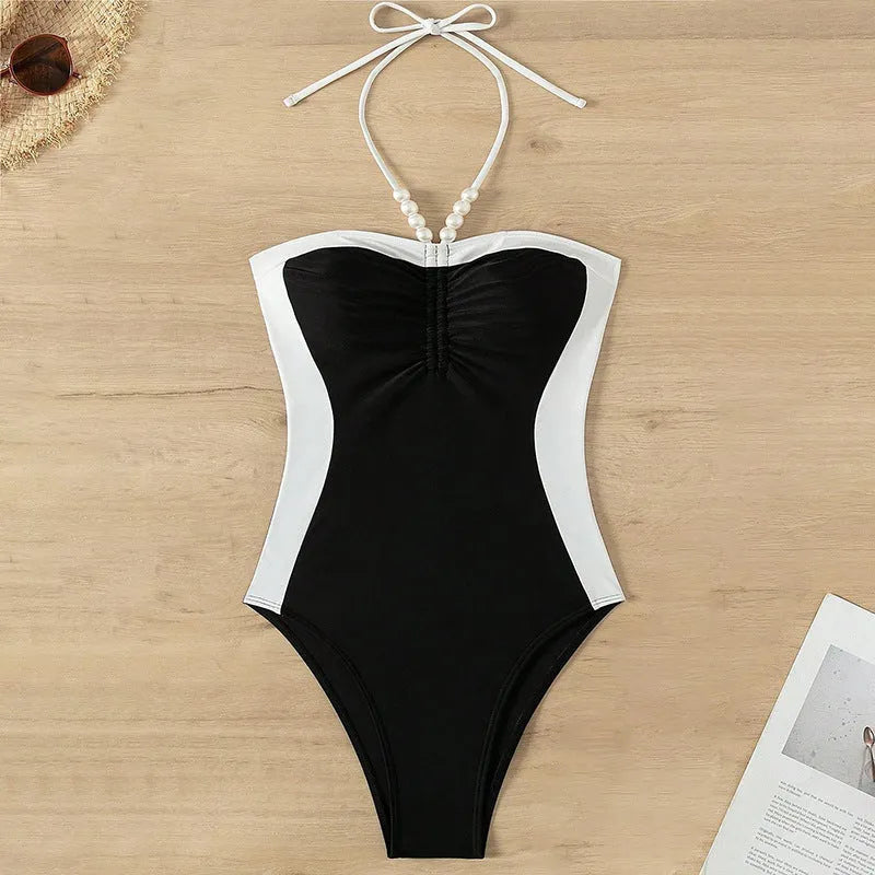 Black and white women's slim fit one-piece swimsuit with pearl spaghetti straps.