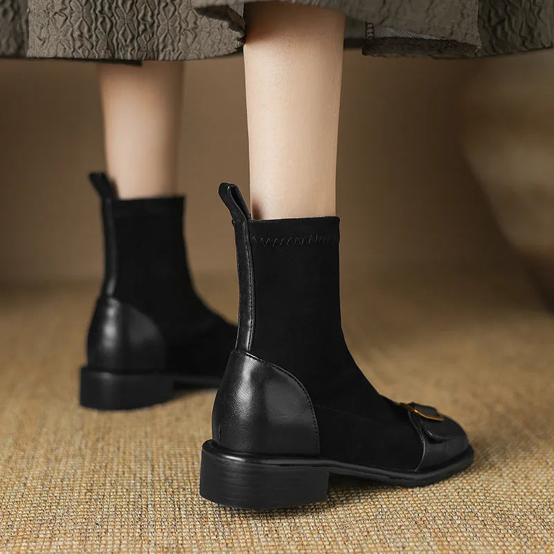 Women's black low heel ankle boots with martin-style buckle stitching and white lace-up front.