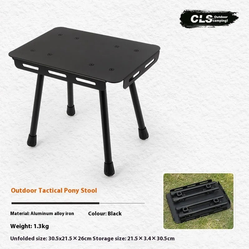 CLS aluminium folding camping stool shown in army green, converted into a small raised table next to a storage bag.