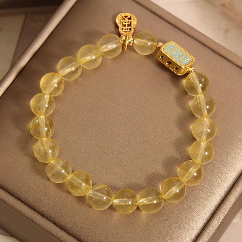 Women's yellow citrine crystal bracelet with sparkling rhinestone details on wrist.