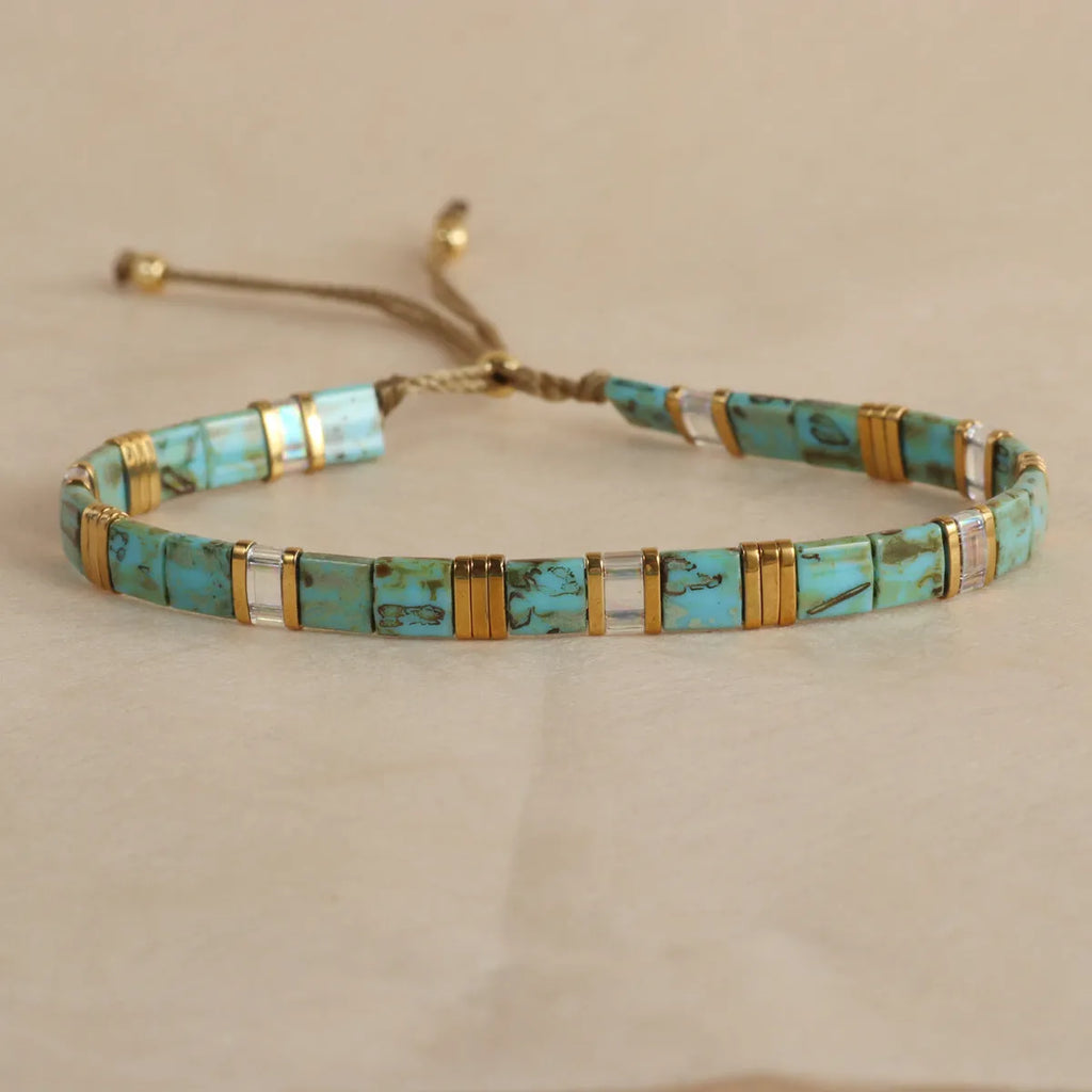 Geometric glass and coloured glaze beaded bracelet with a pull clasp in milky white colour.