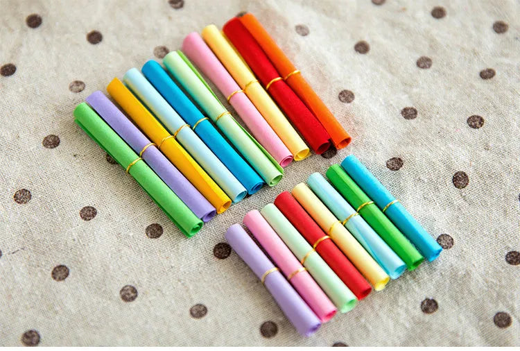 Assorted coloured mini paper scrolls with eyelets in 3x7cm and 7x7cm sizes for drift bottles