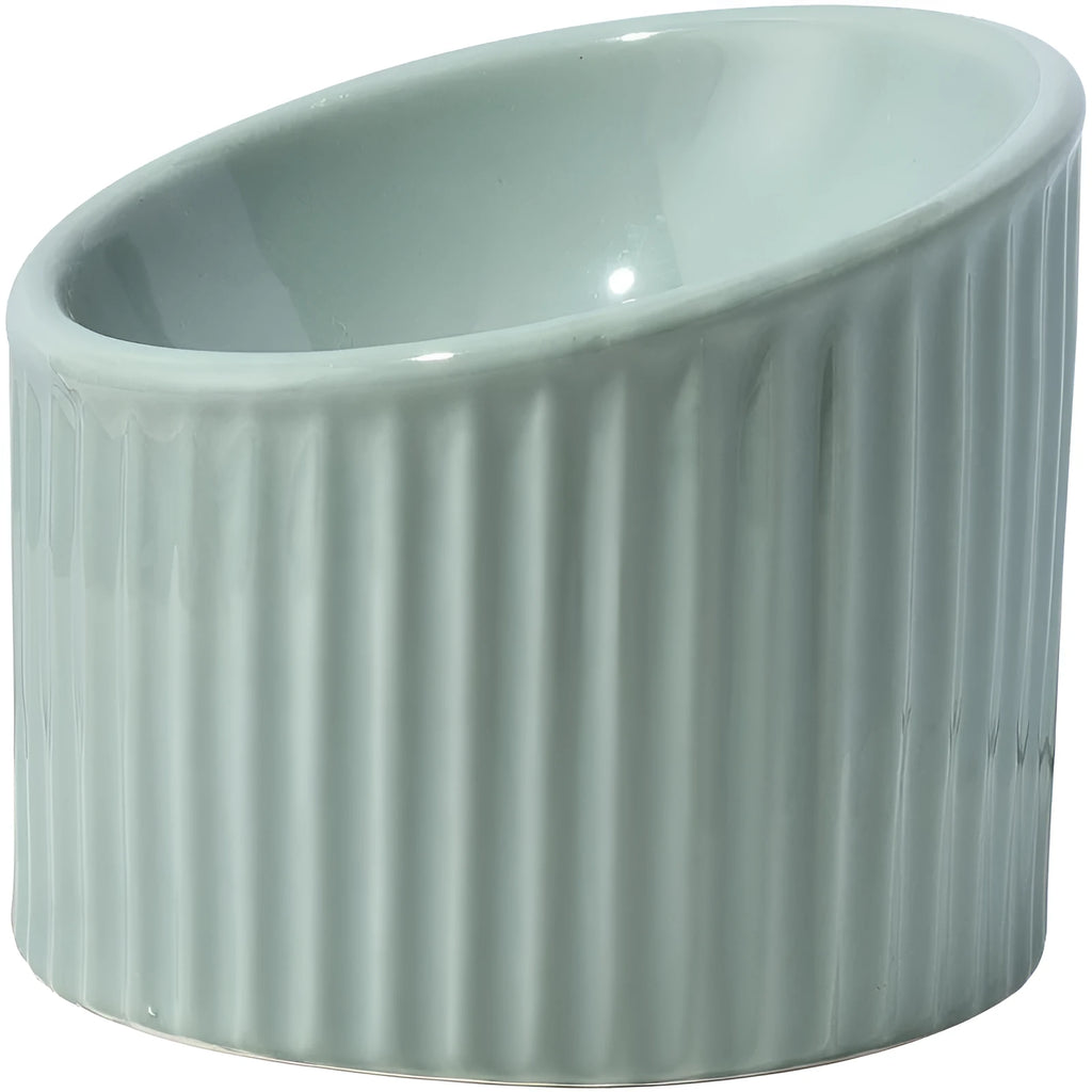 A dark green elevated ceramic cat bowl with a tilted, round design on a wooden surface.