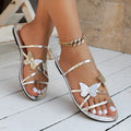Women's butterfly cross-strap flat sandals in black, champagne, gold or silver, artificial PU upper, rubber sole, sizes 36-43
