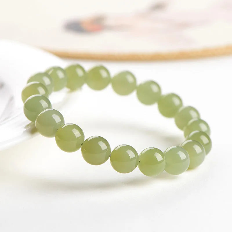 Polished Hetian jade ball bracelet in ice-like clear water colours on a wrist.