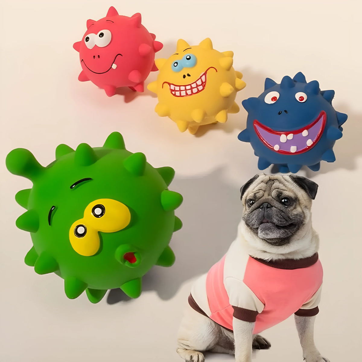 Set of four coloured latex squeaky dog balls with cute face designs on blue green red yellow backgrounds