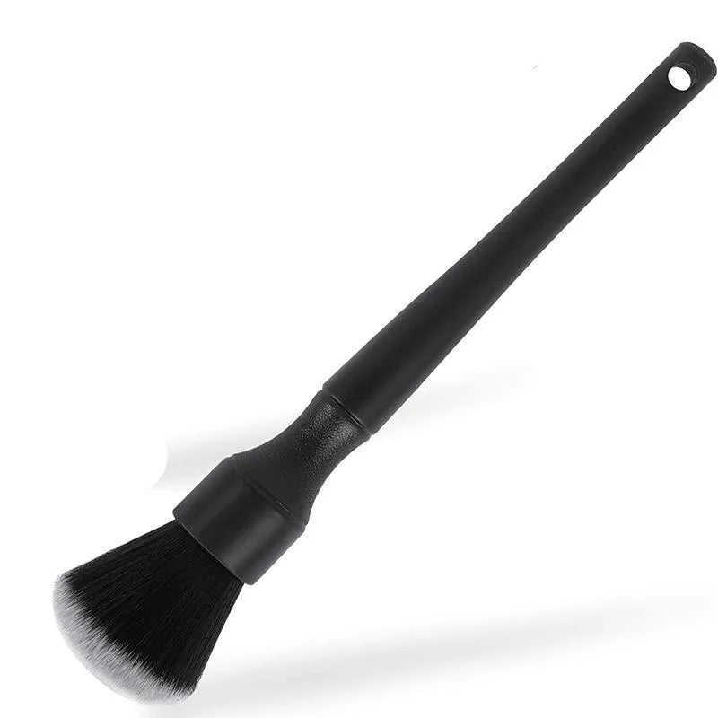 Black ultra-soft pig hair car detailing brush with PP plastic handle on a car seat.
