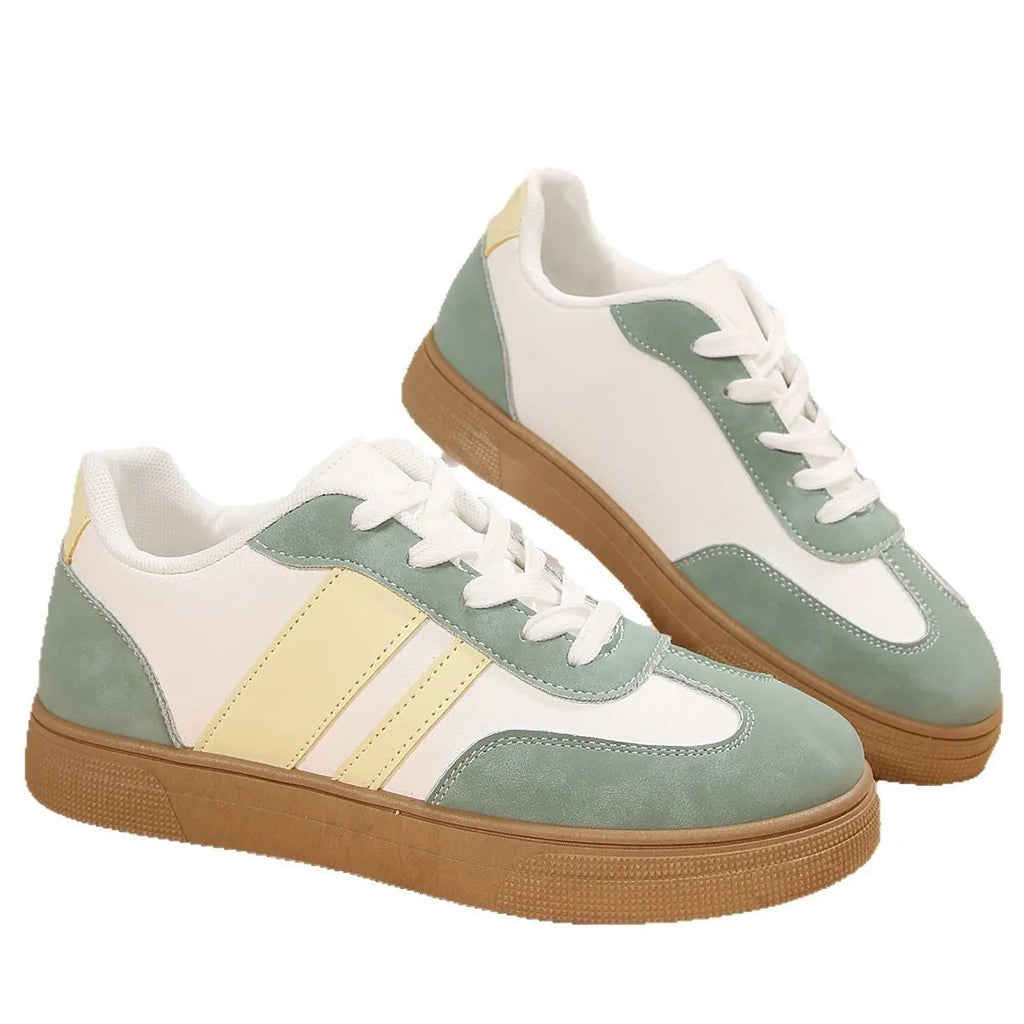 Green women's retro sports pumps with cross straps, flat rubber sole, and round toe on a white background.