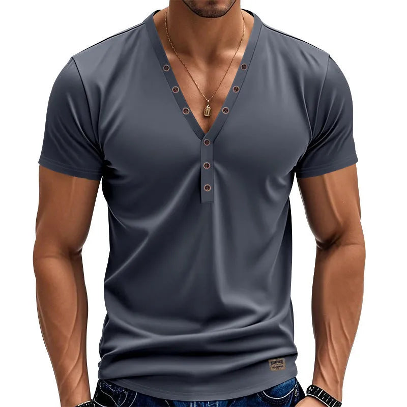 Man wearing a loose fit grey v-neck pullover top with button detail on the neckline