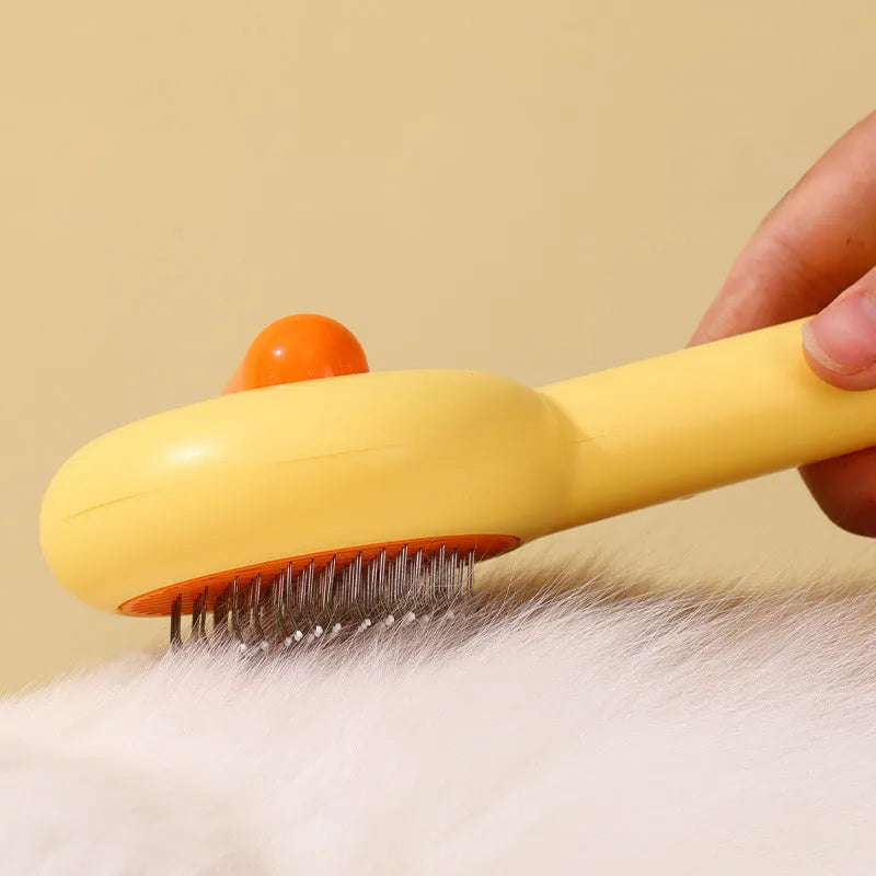 Small yellow duck-shaped pet grooming comb with open sections and needle teeth