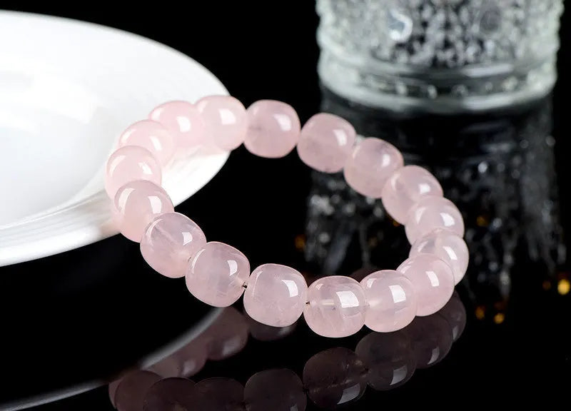 Pink barrel crystal bead bracelet with geometric design on wrist.