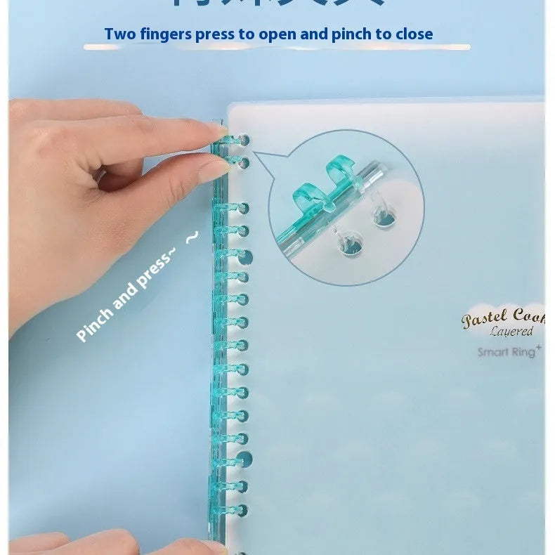 Refillable spiral notebook in pastel blue with loose-leaf paper visible.