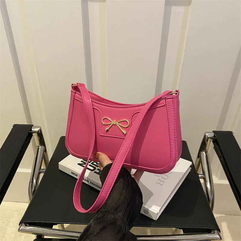 PU leather shoulder bag with bow decoration in a horizontal square shape, shown in one of six available colours.