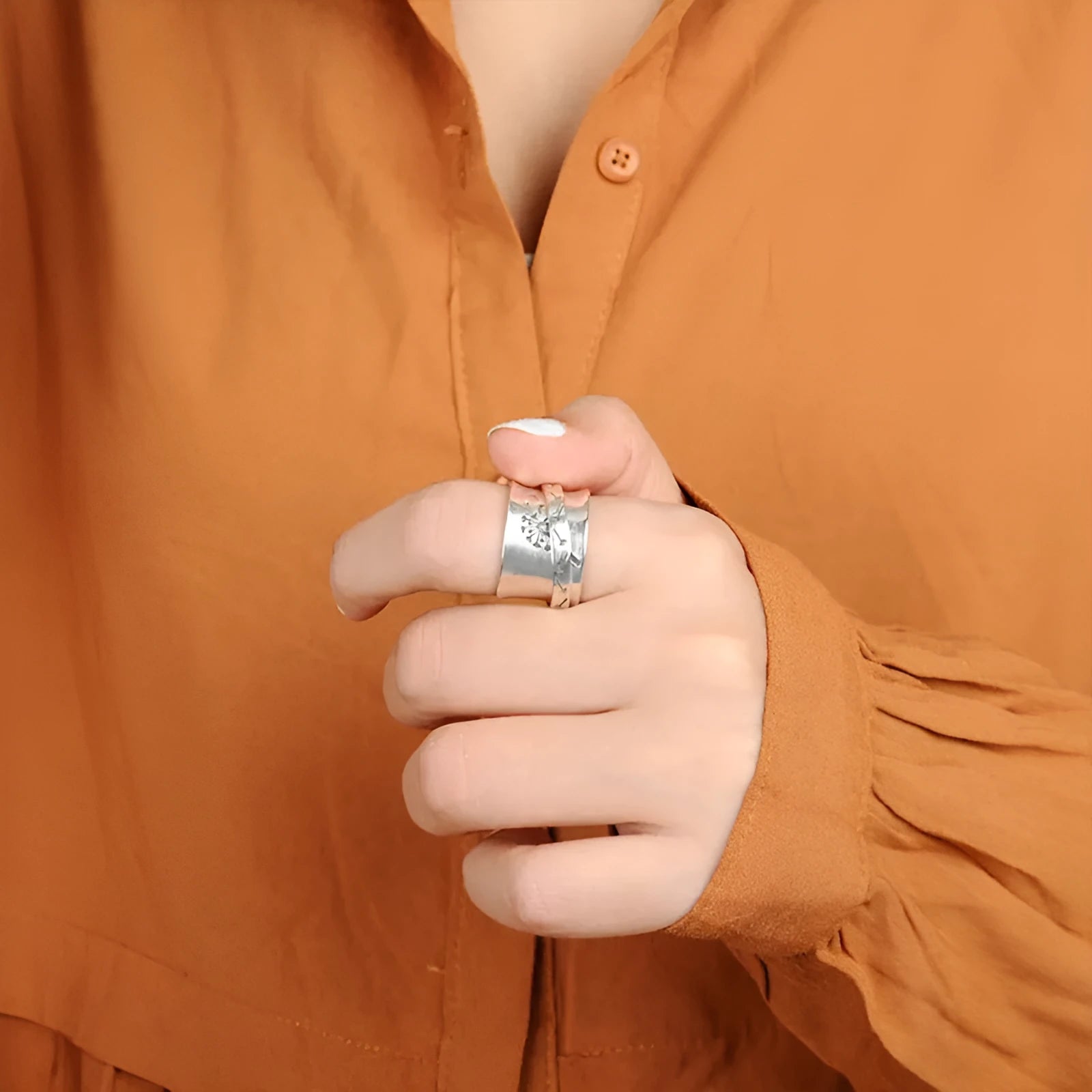 Silver rotatable flower ring showing petal detail and band, displayed with sizing options 7 through 11