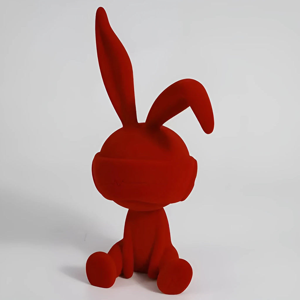 Small resin rabbit ornament wearing a suede blindfold, shown in blue, green, and red colour options.