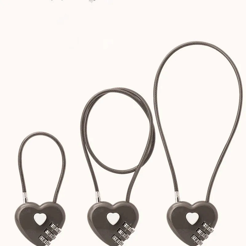 Heart-shaped wire rope lock in various colours with a steel cable, shown securing a bicycle helmet.