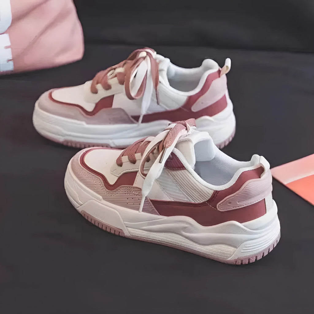 Pink and white low-top sneaker with a height-increasing rubber sole.