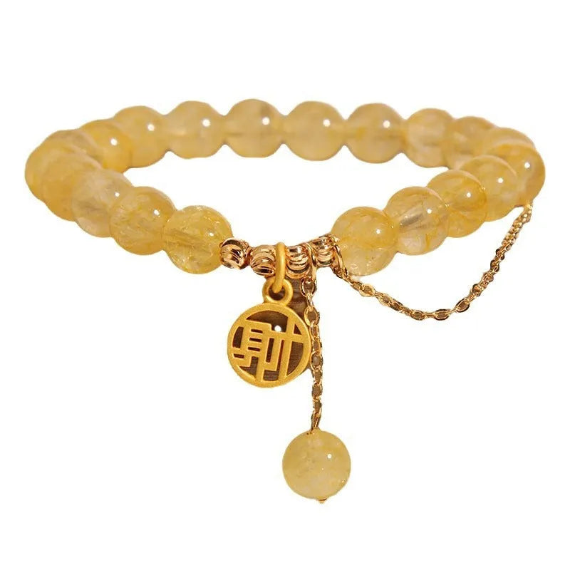Close-up of a women's natural citrine bracelet with an electroplated Chinese character tassel.