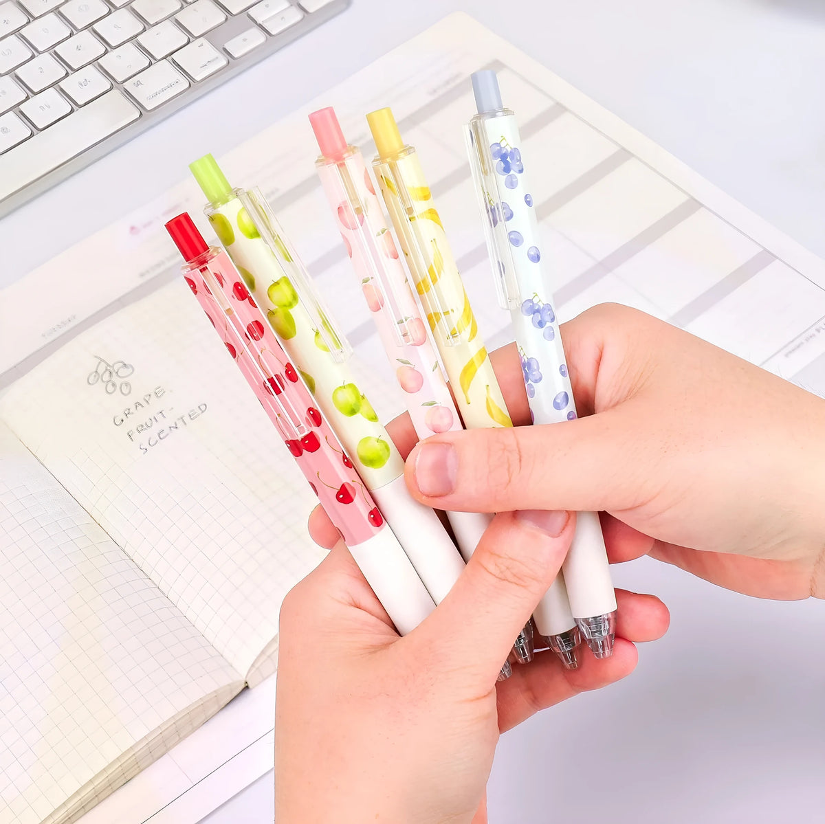 Three fruit-scented pressurised pens with push-button mechanisms and 0.5mm black refills