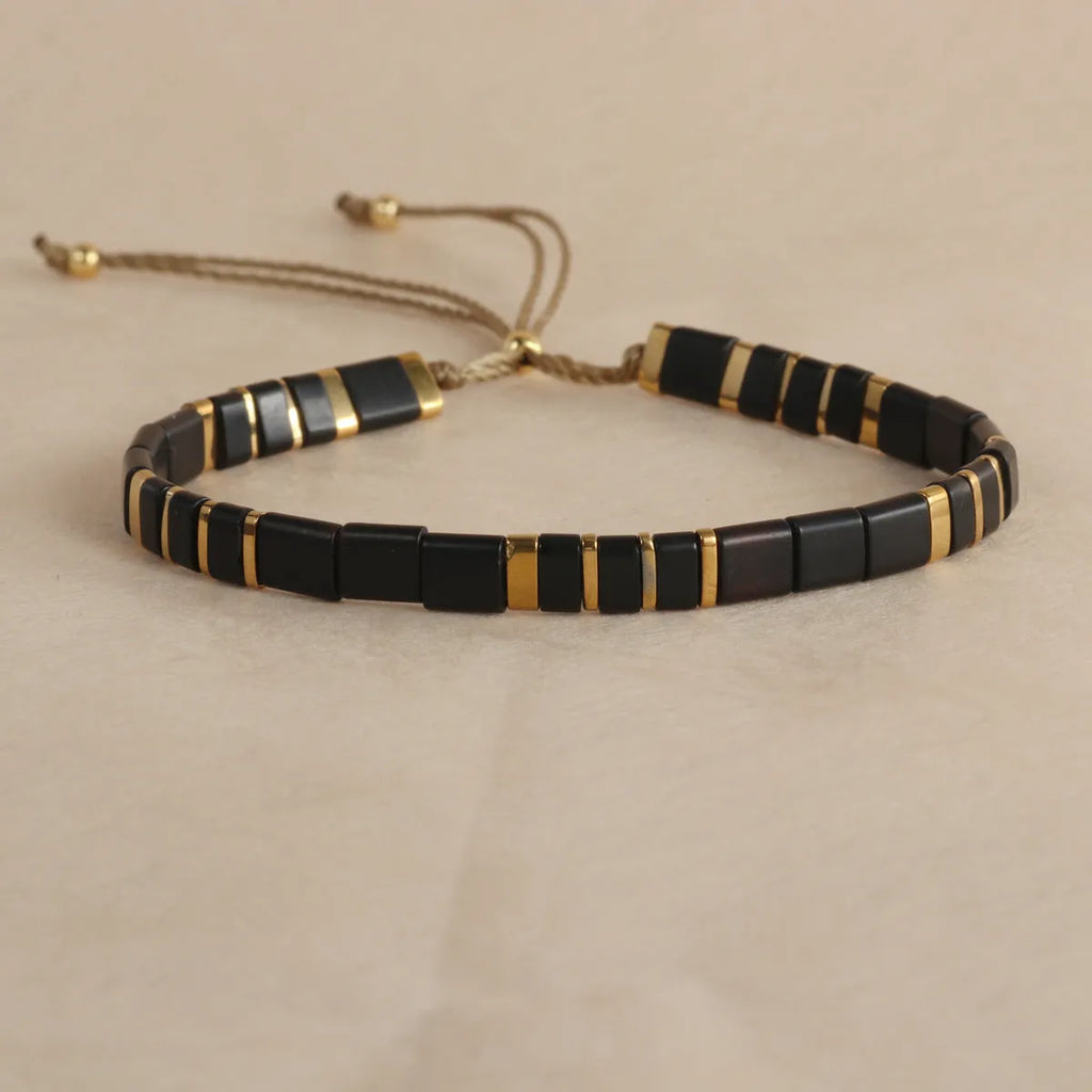 Geometric glass and coloured glaze beaded bracelet with a pull clasp in milky white colour.
