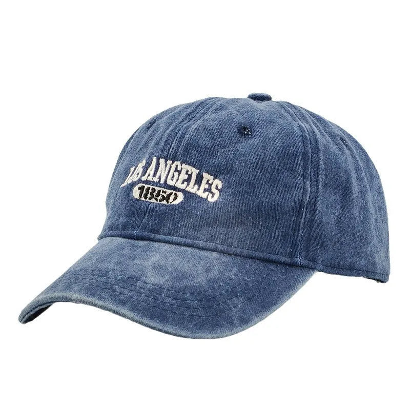 Retro-style adjustable acrylic peaked cap with embroidered letters, shown in a distressed beige colour.