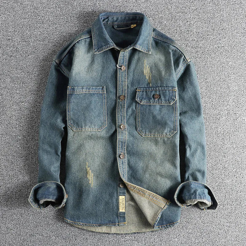 Men's light blue washed vintage denim shirt with a loose fit and long sleeves on a hanger.