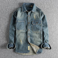 Men's light blue washed vintage denim shirt with a loose fit and long sleeves on a hanger.