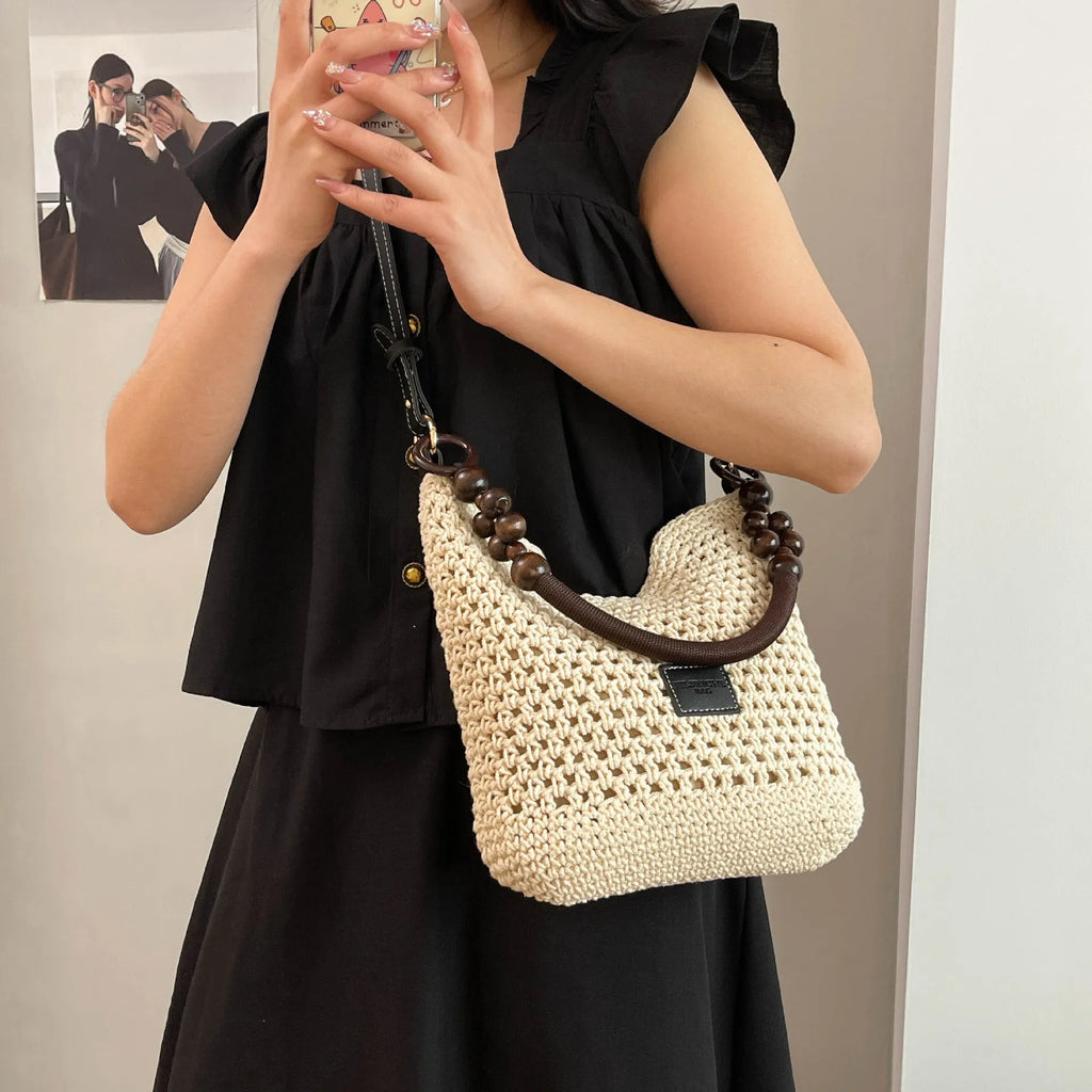 Knitted tote beach bag showing bucket shape, contrast stitching, and zippered internal pocket in black colour