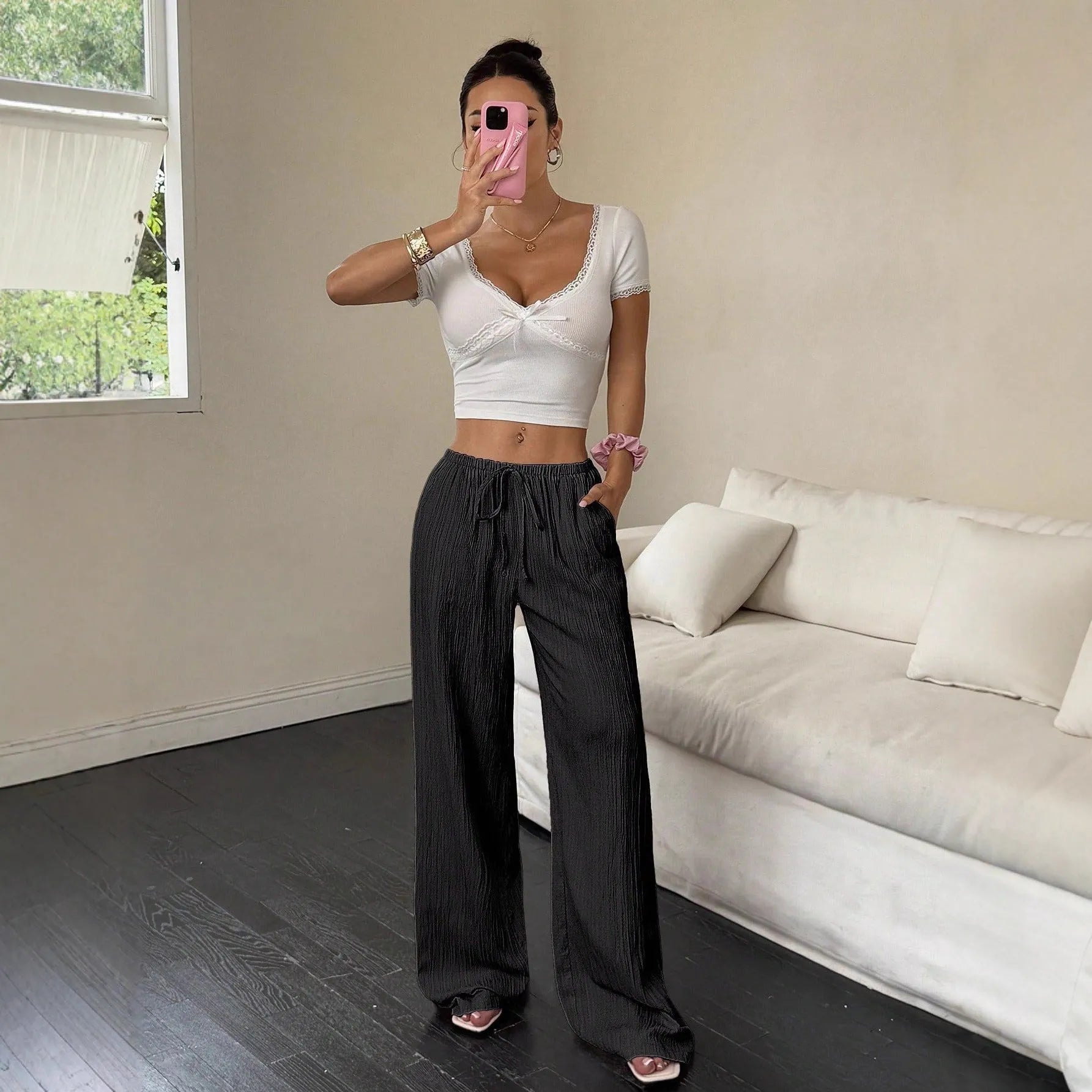 Women's black wide-leg trousers with lace-up waist detail on hanger