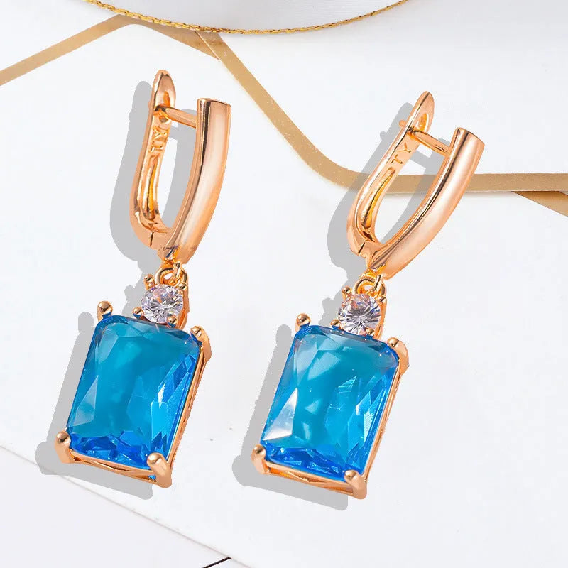 A pair of square gold and silver geometric electroplated earrings with a quadrilateral design.