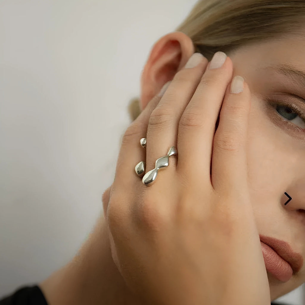 Gold and silver brass opening ring with sphere circle design on a woman's hand.