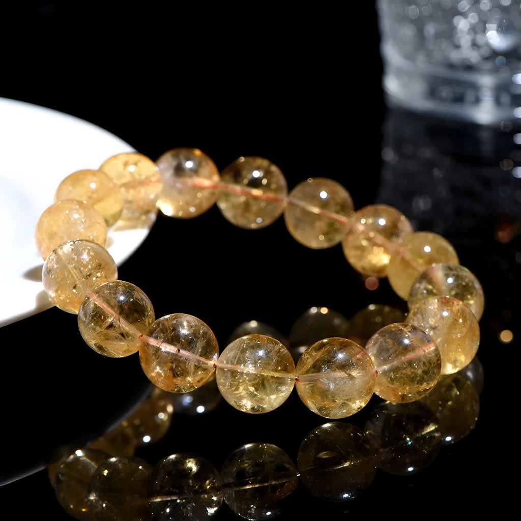 Natural yellow citrine gemstone bracelet with geometric beads on a white background.