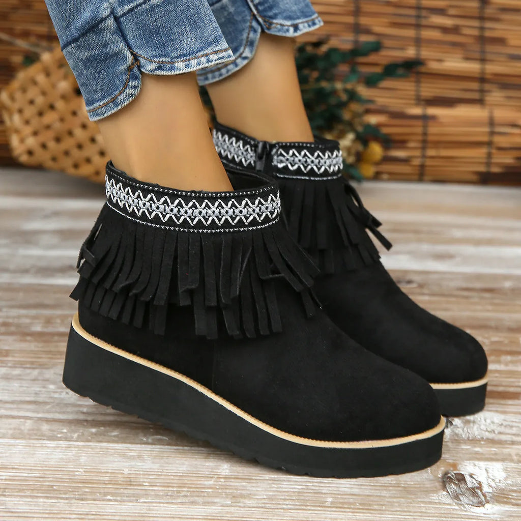 Women's suede ankle booties with a wedge heel, side zipper, tassel detail, and thick rubber sole.