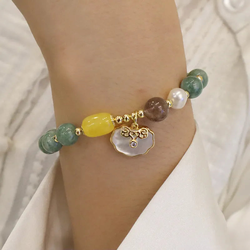 Green jade beaded bracelet with a silver-toned shell charm on an adjustable black cord.