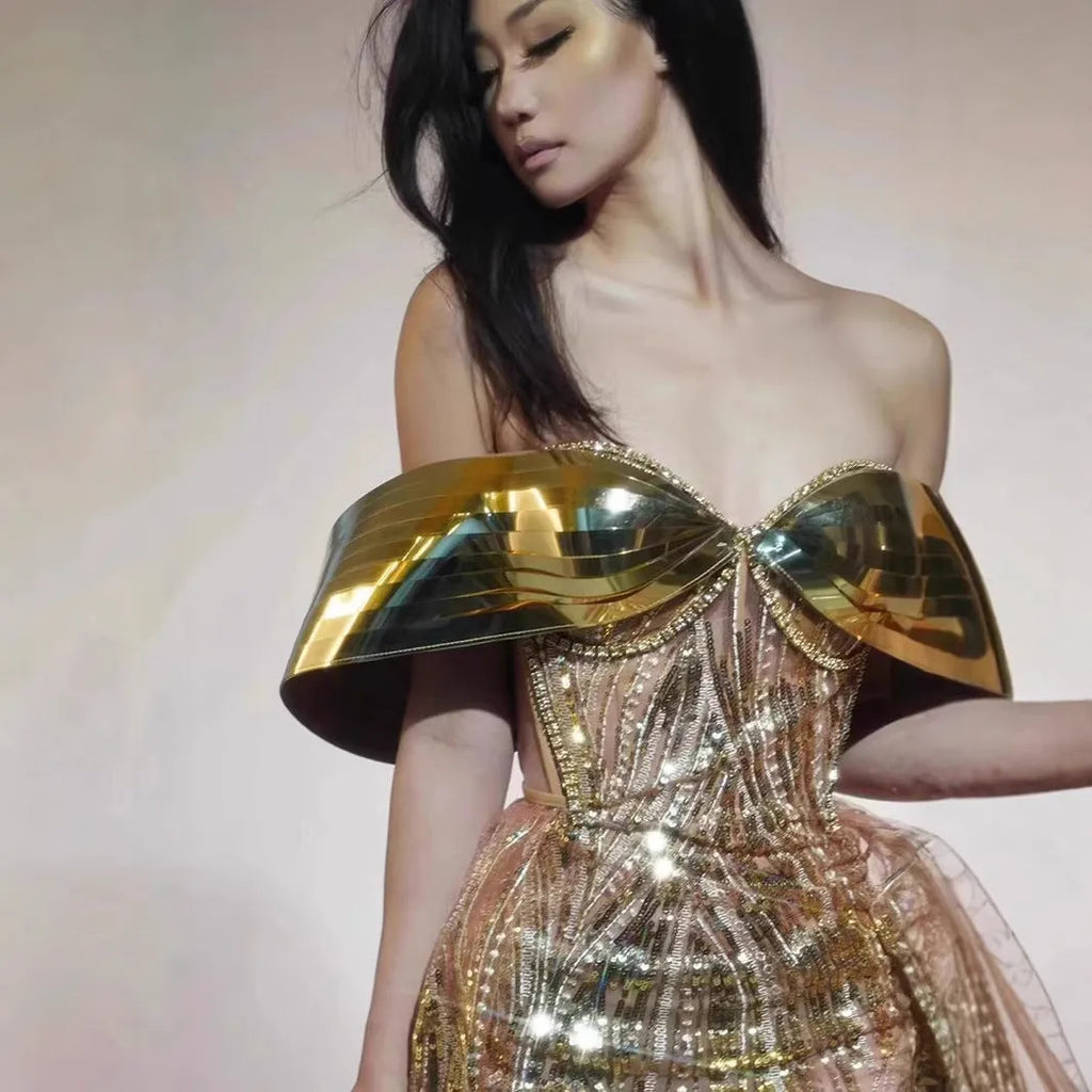 Gold strapless sequined evening dress with a long tulle skirt and a high side split.