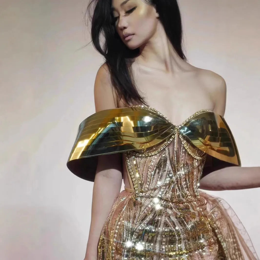 Gold strapless sequined evening dress with a long tulle skirt and a high side split.
