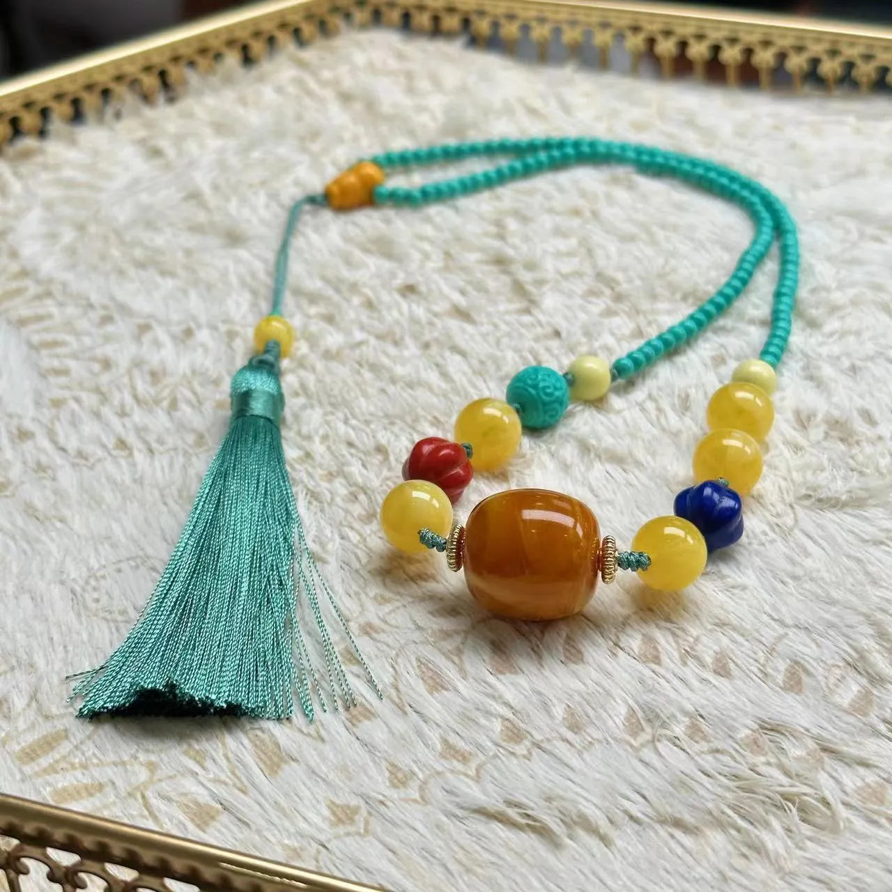 Turquoise mesh flower lucky pendant necklace with adjustable ball bead chain on display