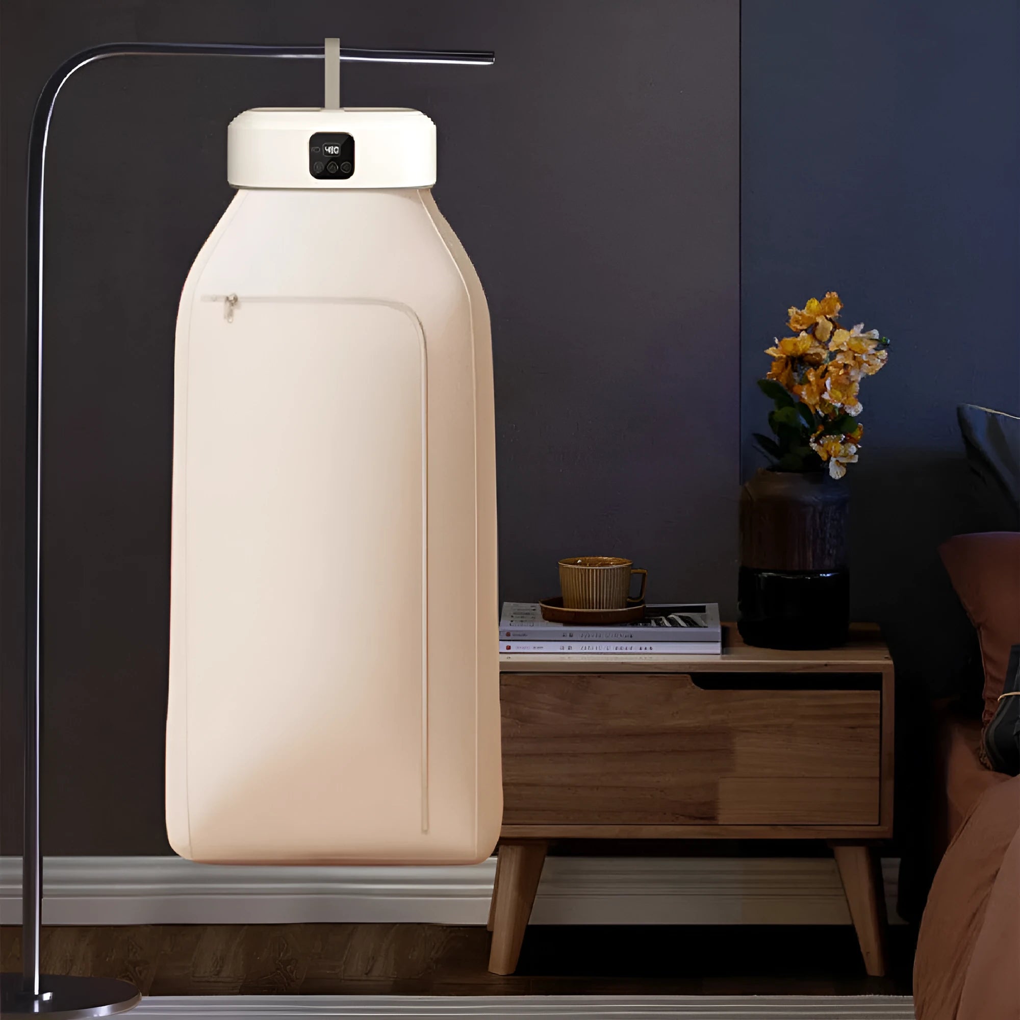 White cylindrical compact laundry drier with remote control on countertop