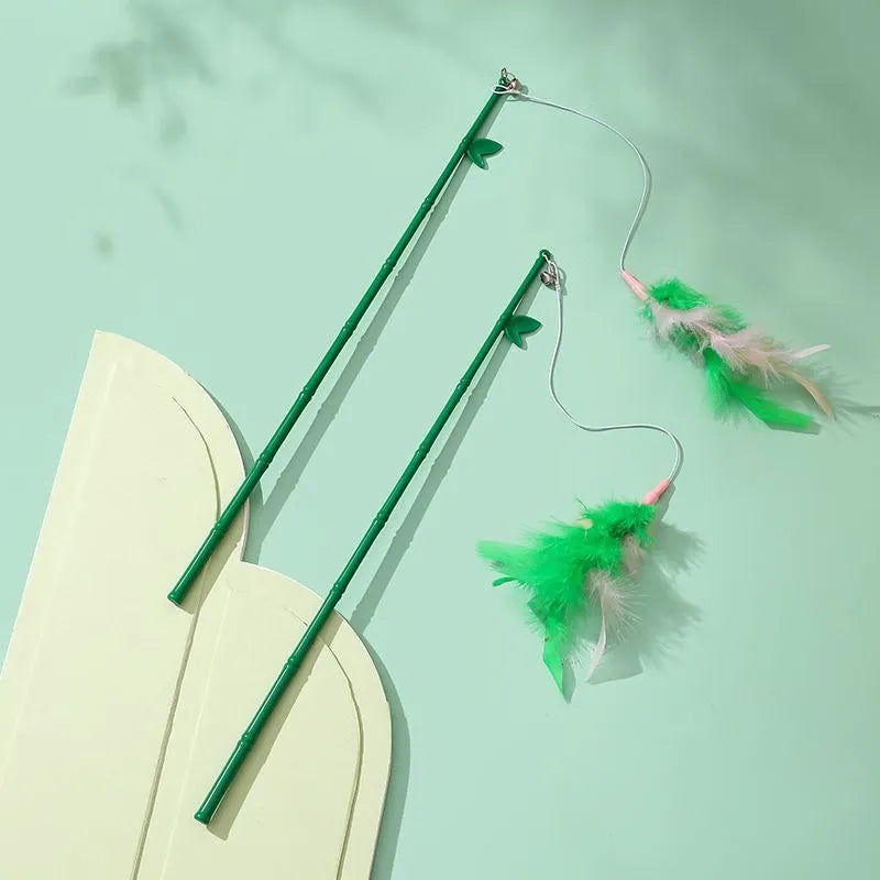 Green interactive cat feather wand toy with bells attached for indoor play and training