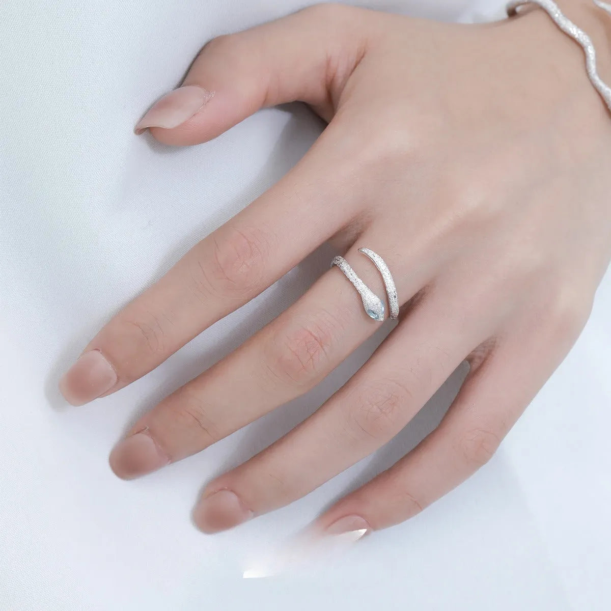 Silver adjustable snake ring with platinum colour finish on a white background
