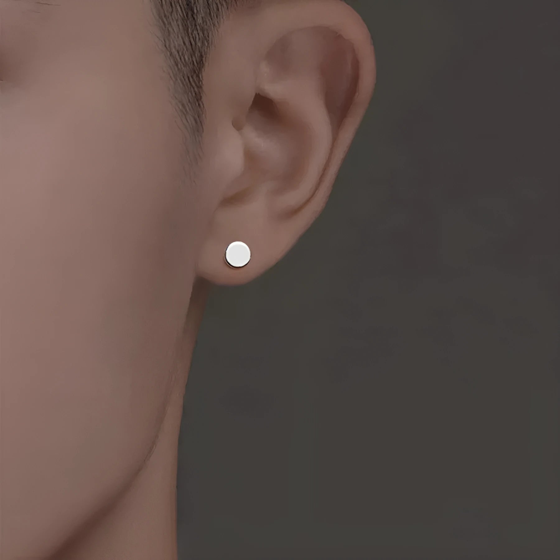 A pair of flat, round S999 sterling silver ear studs on a plain background, shown in silver and black colour options.
