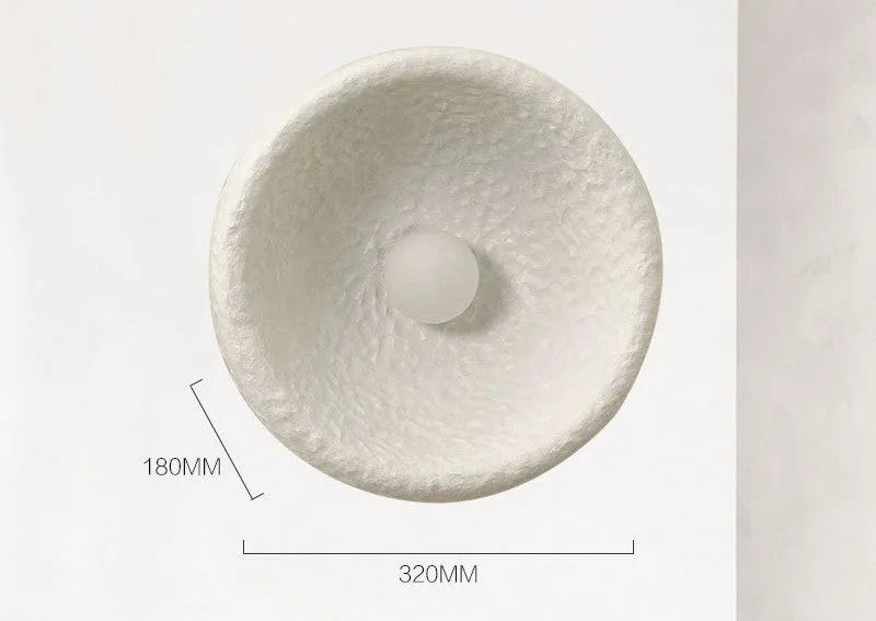 Japanese-style simple silent wall lamp with white resin shade in a modern room setting.